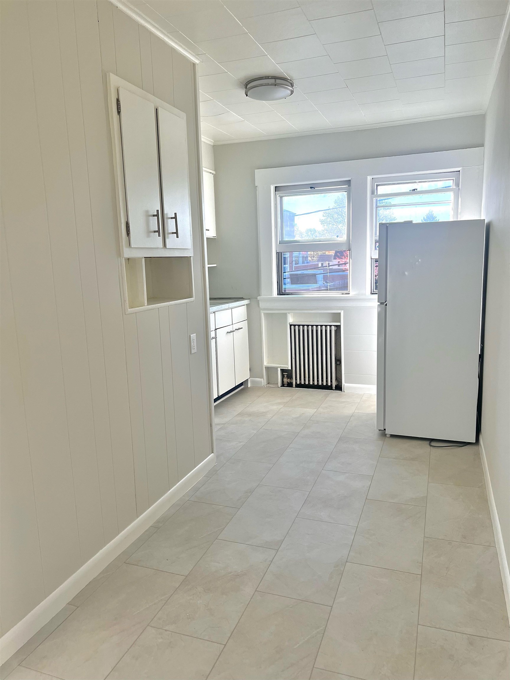128 Hazelton Street, Unit 2 Ridgefield Park, NJ 07660 - Photo 5 of 6 an empty room with windows and cabinet