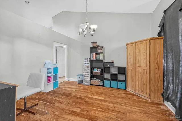 a spacious bedroom with a bed and a chandelier