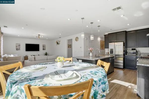 a dining room with kitchen island granite countertop furniture and a view of kitchen