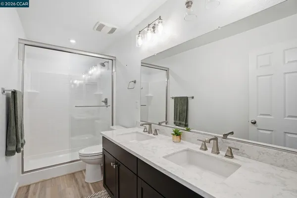 a bathroom with a granite countertop sink toilet and shower