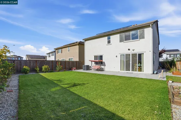 a view of a white house in front of a big yard