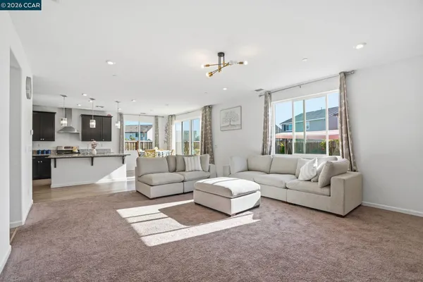 a living room with furniture and view of kitchen