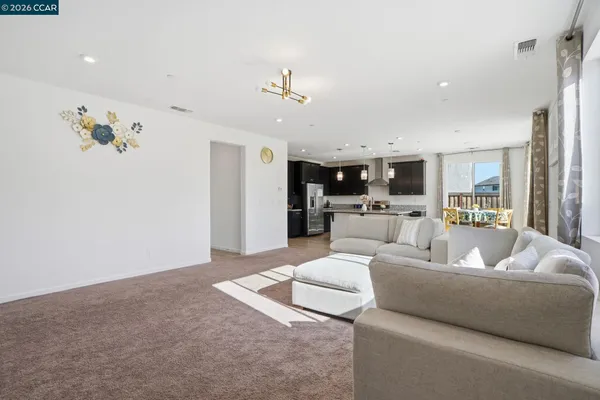a living room with furniture and kitchen view