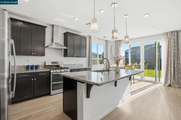 a kitchen with stainless steel appliances granite countertop a sink a stove and a refrigerator