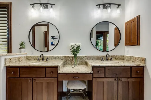 a bathroom with a granite countertop double vanity sink and a mirror