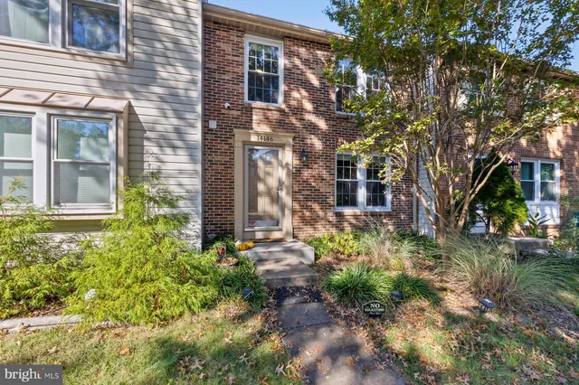 a view of a house with a yard and potted plants