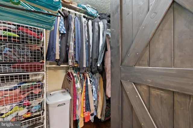 a view of walk in closet with clothes and shoes