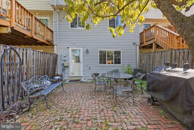 a view of a chairs and table in the back yard of the house