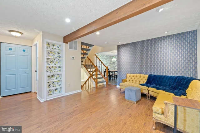 a living room with furniture and wooden floor