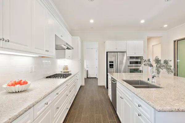 a kitchen with stainless steel appliances a sink stove and cabinets