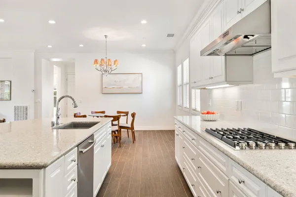 a kitchen with kitchen island granite countertop a sink a counter space and stainless steel appliances