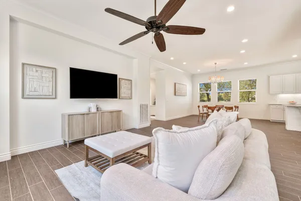 a living room with furniture a flat screen tv and a window