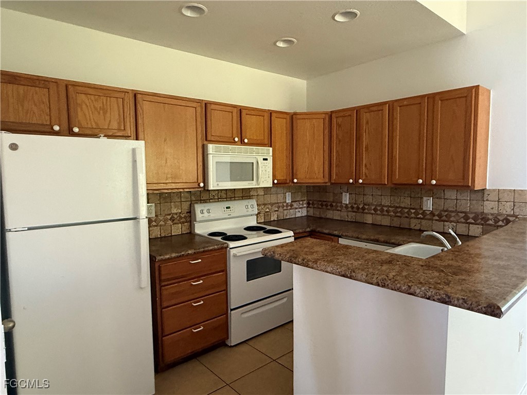 633 Alabama Road South, Unit 635 Lehigh Acres, FL 33974 - Photo 13 of 19 a kitchen with a refrigerator sink and microwave