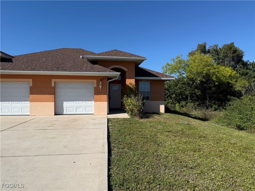 633 Alabama Road South, Unit 635 Lehigh Acres, FL 33974 - Photo 2 of 19 a front view of a house with a yard