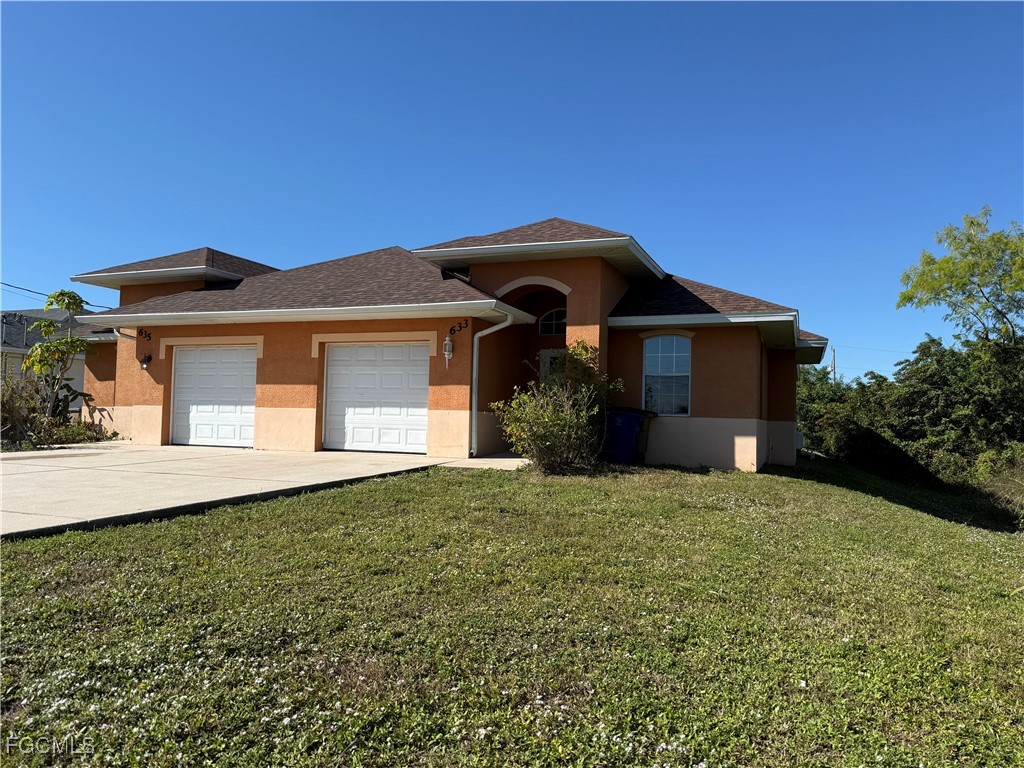 633 Alabama Road South, Unit 635 Lehigh Acres, FL 33974 - Photo 3 of 19 a front view of a house with a garden