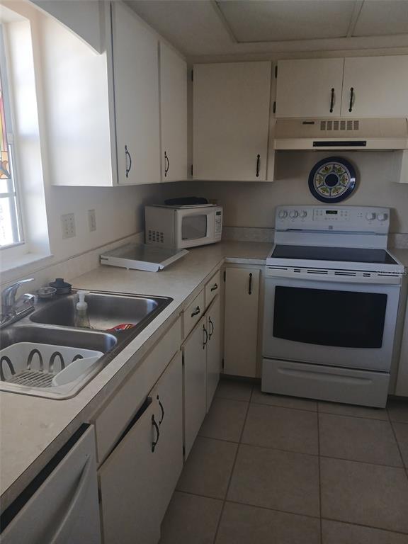 1531 Placida Road, Unit 201 Englewood, FL 34223 - Photo 12 of 25 a kitchen with a stove and white cabinets