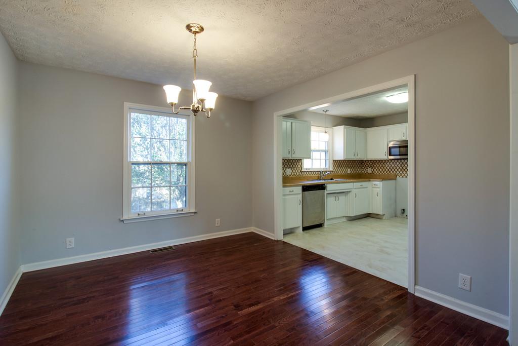 3280 Anderson Road Antioch, TN 37013 - Photo 6 of 30 an empty room with wooden floor a kitchen view and windows