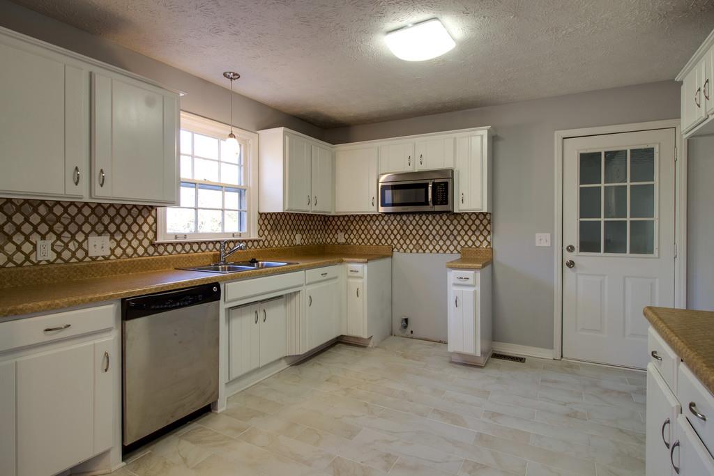 3280 Anderson Road Antioch, TN 37013 - Photo 9 of 30 a kitchen with granite countertop a stove a sink and a microwave