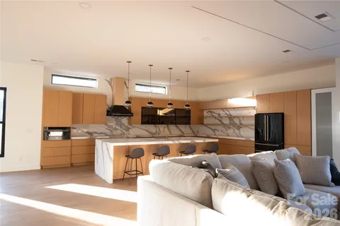 a living room with stainless steel appliances kitchen island granite countertop furniture and a kitchen view