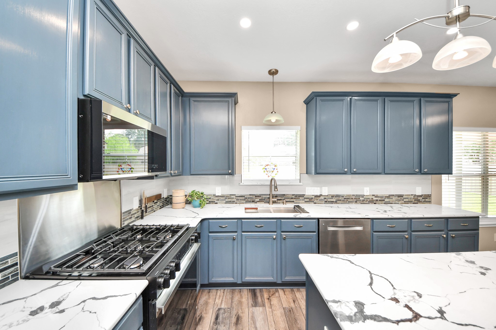 7622 McCormick Mill Court Houston, TX 77095 - Photo 5 of 37 a kitchen with stainless steel appliances a sink a stove a microwave cabinets and a counter top space