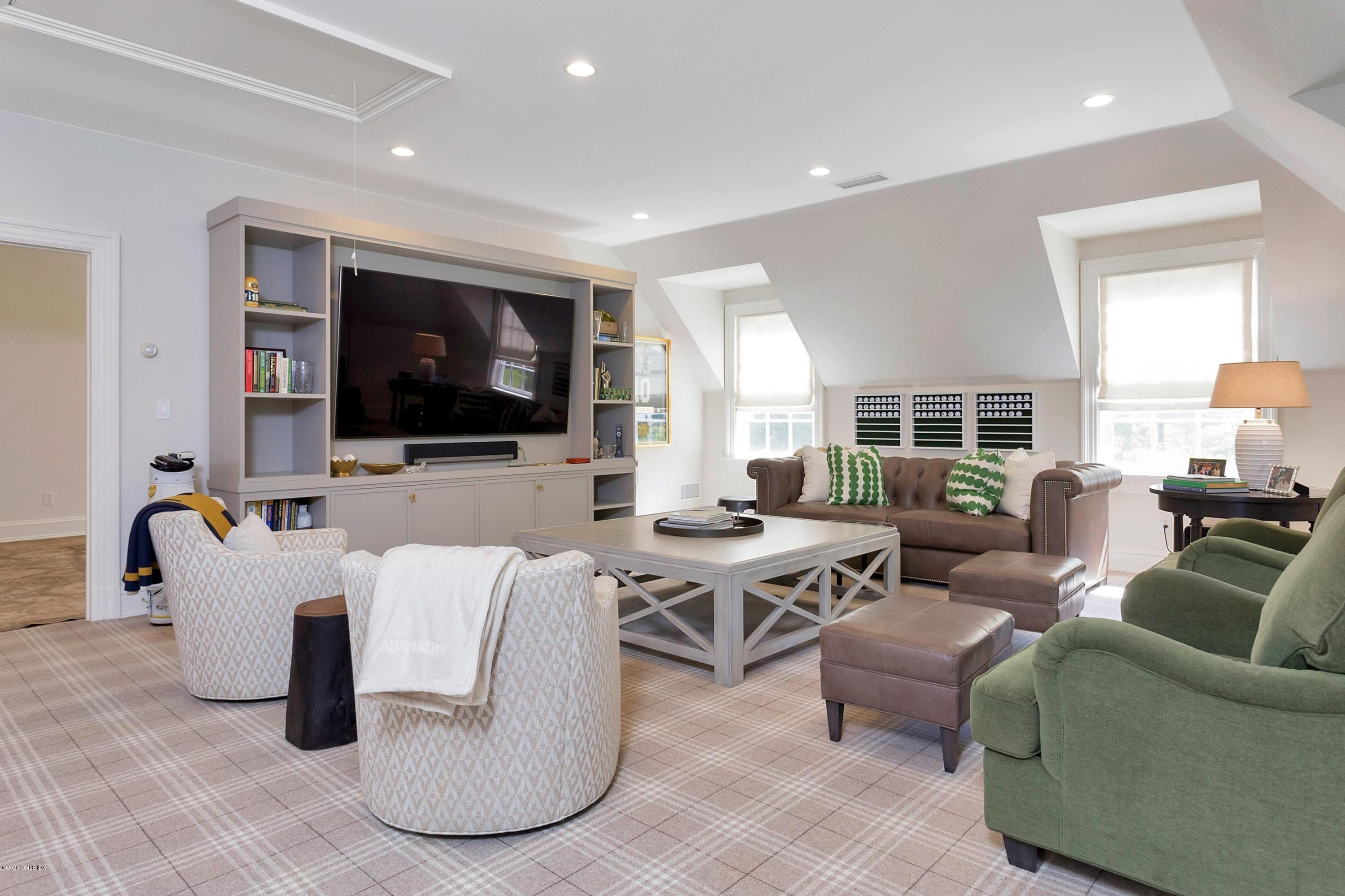 122 Butternut Hollow Road Greenwich, CT 06830 - Photo 16 of 36 a living room with furniture a flat screen tv and large window