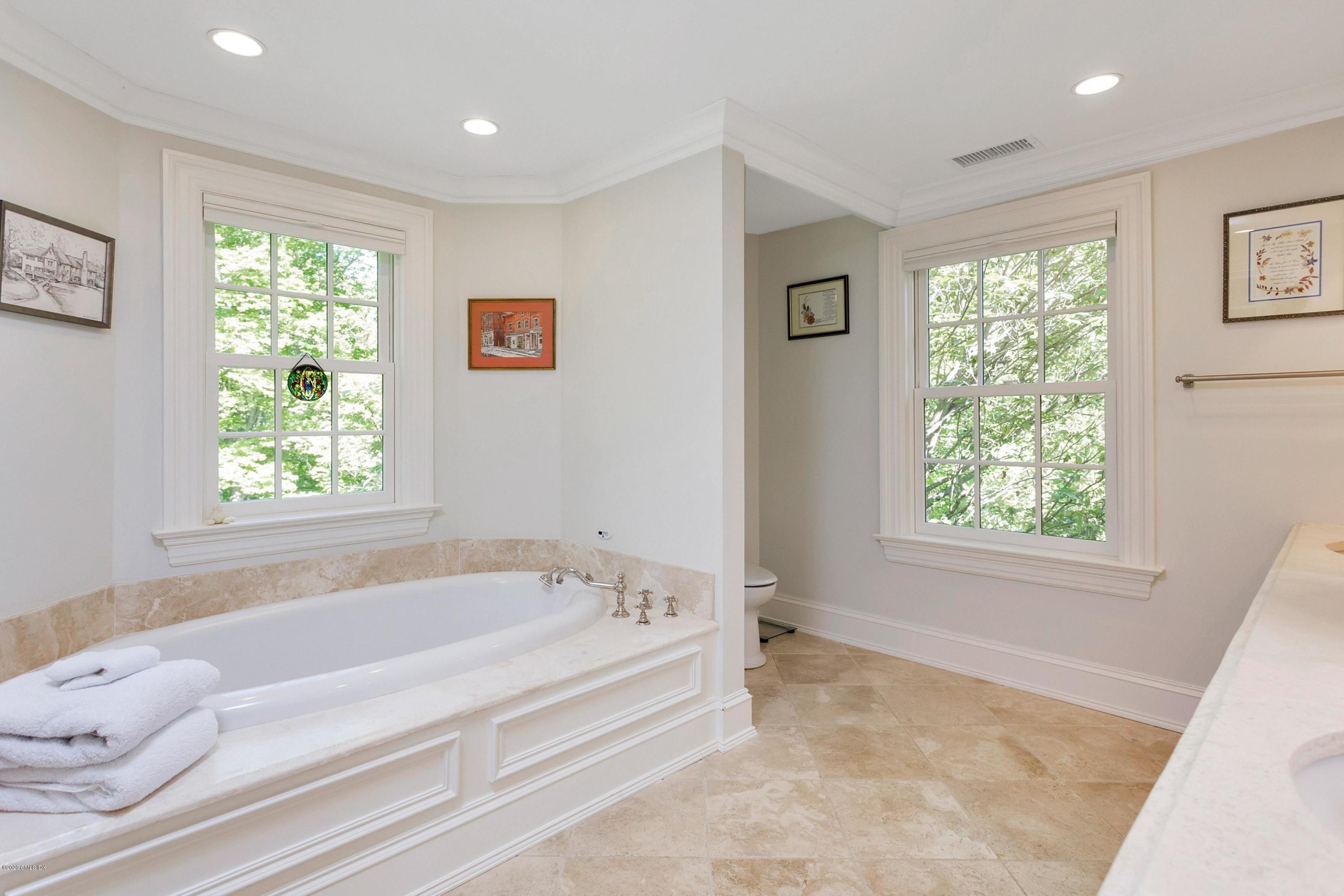 122 Butternut Hollow Road Greenwich, CT 06830 - Photo 23 of 36 a spacious bathroom with a bathtub and window