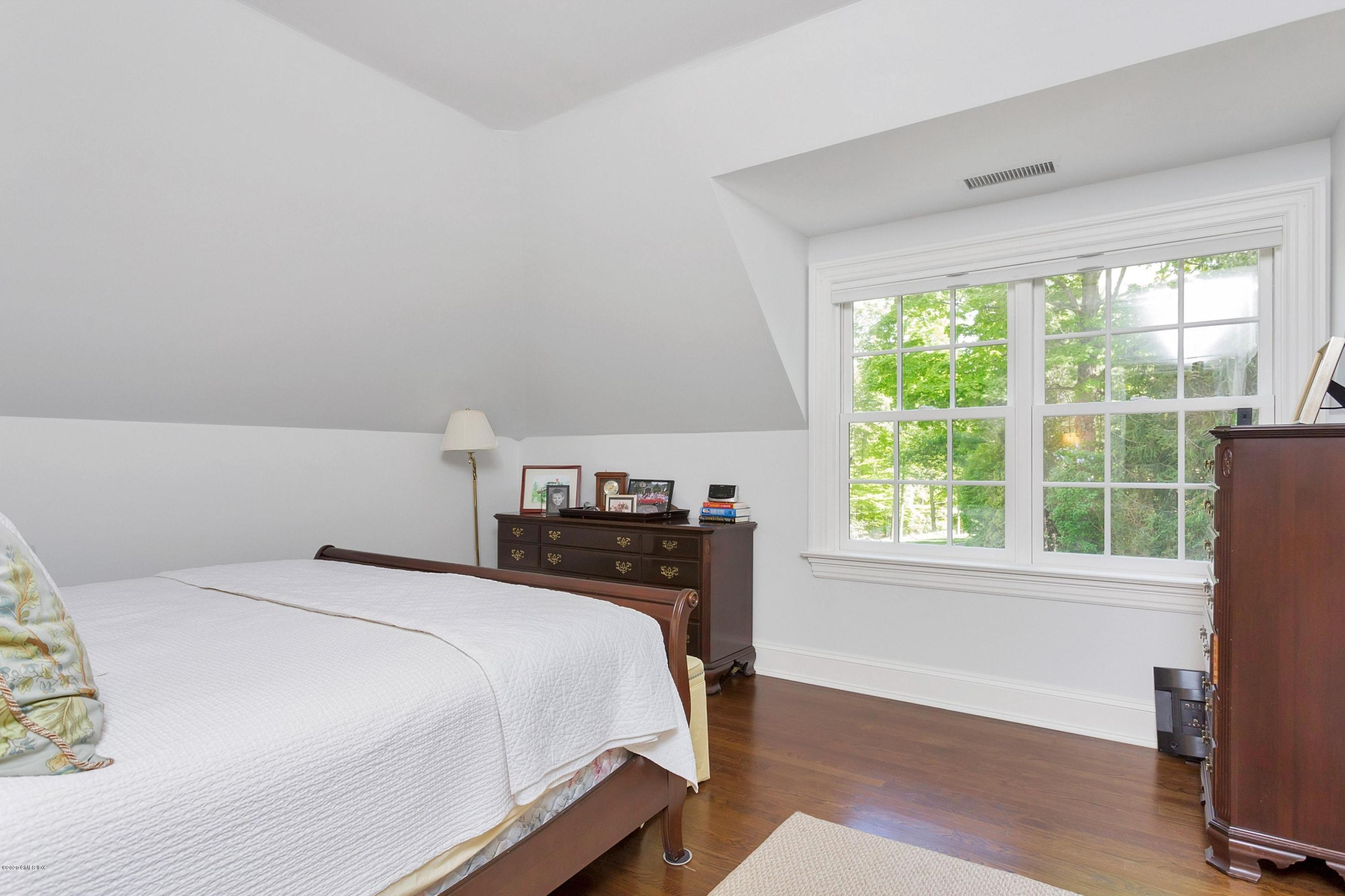 122 Butternut Hollow Road Greenwich, CT 06830 - Photo 24 of 36 a bedroom with a bed and wooden floor