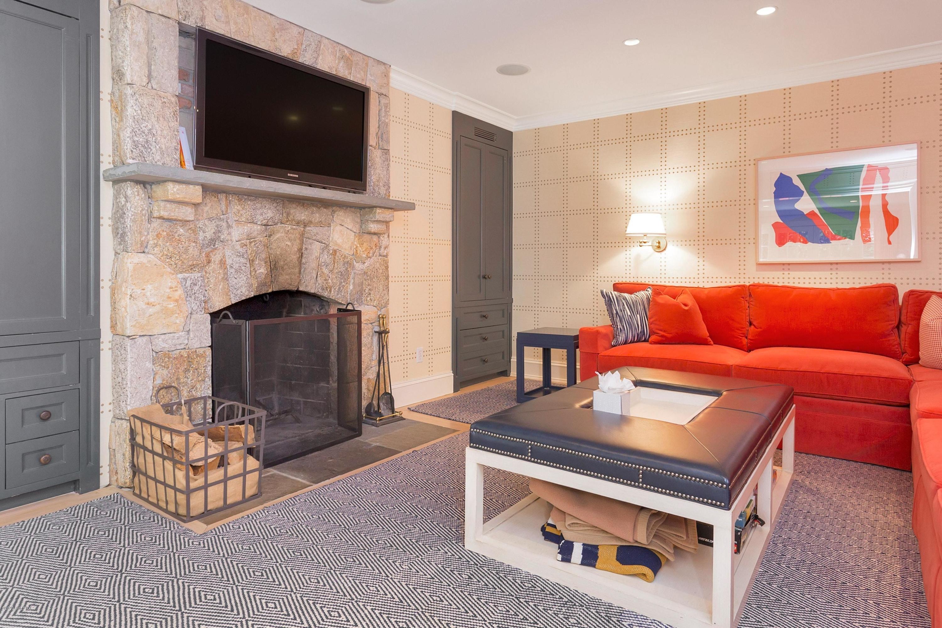 122 Butternut Hollow Road Greenwich, CT 06830 - Photo 10 of 36 a living room with furniture a flat screen tv and a fireplace