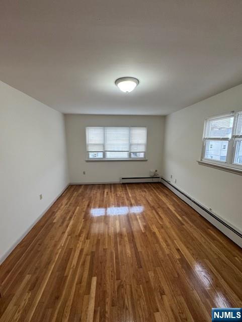 115 Gaston Avenue, Unit 2 Garfield, NJ 07026 - Photo 4 of 8 an empty room with wooden floor and windows