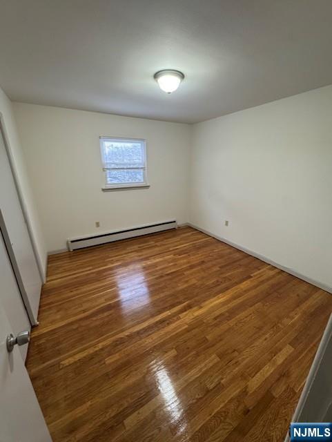 115 Gaston Avenue, Unit 2 Garfield, NJ 07026 - Photo 5 of 8 an empty room with wooden floor and windows