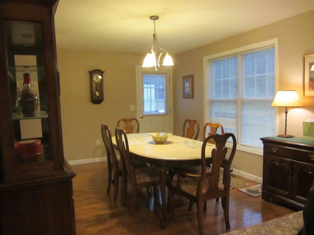 1161 B Mammoth Road, Unit B Pelham, NH 03076 - Photo 5 of 14 a view of a a dining room with furniture window and wooden floor