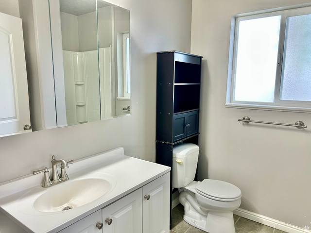 672 West 720 South Logan, UT 84321 - Photo 7 of 15 Bathroom featuring a white vanity with integrated sink, brushed nickel faucet, and a large mirrored medicine cabinet