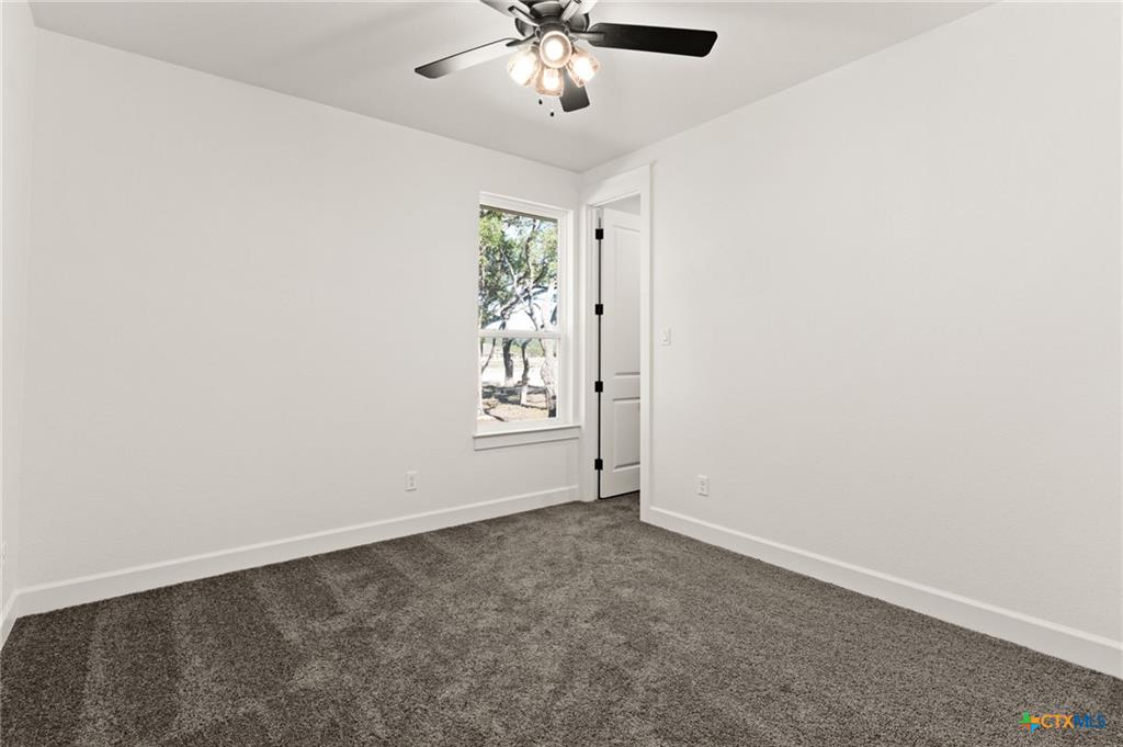 4237 Cold Springs Road Kempner, TX 76539 - Photo 25 of 33 Empty room with dark carpet and a ceiling fan