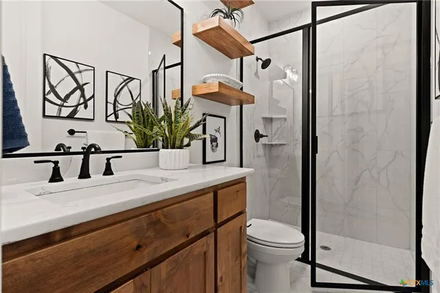 a bathroom with a sink a toilet and shower