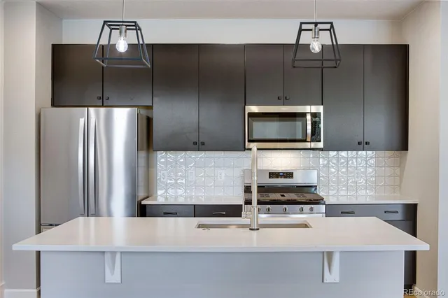a kitchen with kitchen island a counter appliances and cabinets