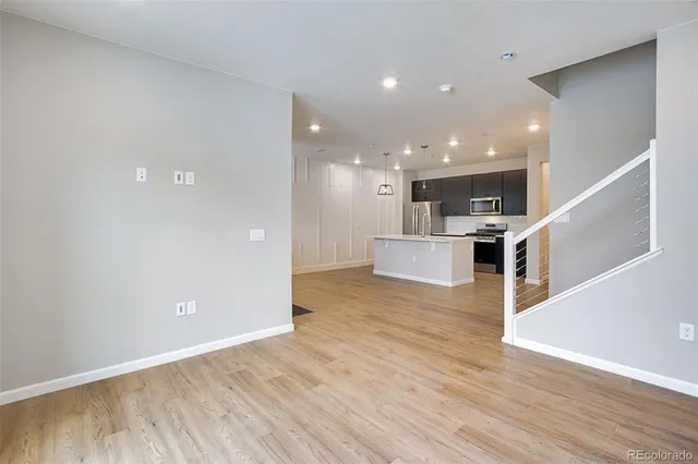 a view of kitchen and hall with wooden floor