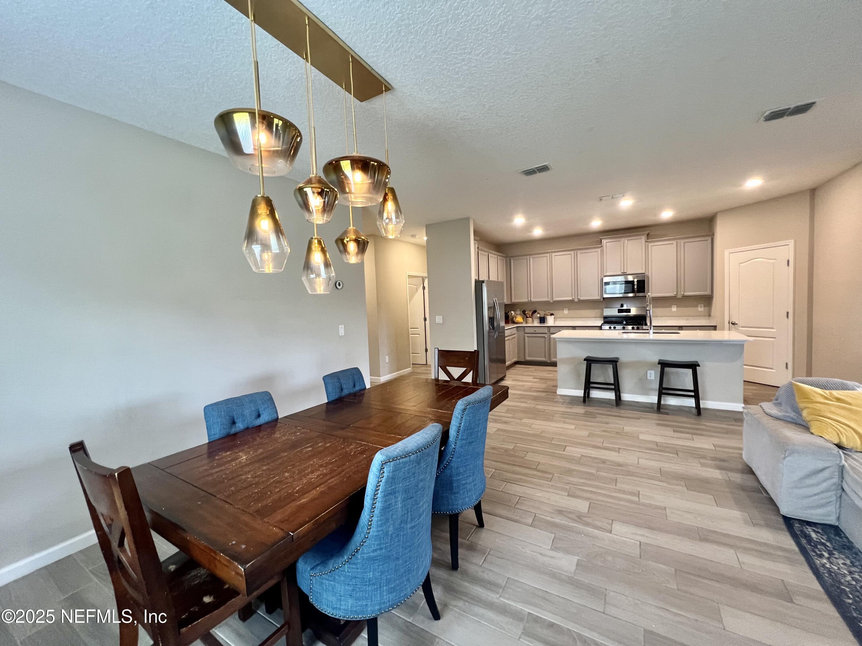 128 Ash Breeze Cove St. Augustine, FL 32095 - Photo 13 of 57 a living room with stainless steel appliances kitchen island granite countertop furniture wooden floor and a rug