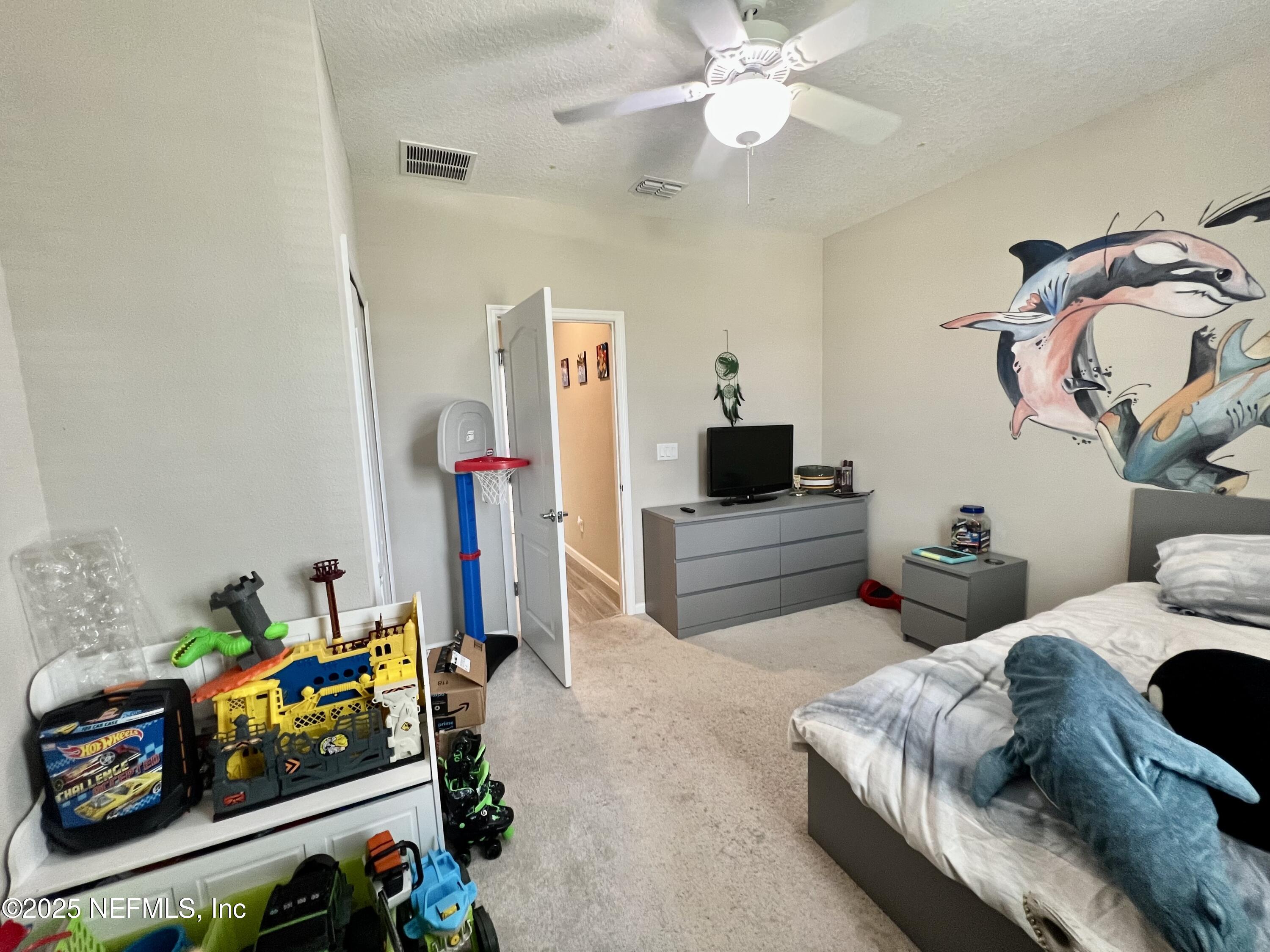 128 Ash Breeze Cove St. Augustine, FL 32095 - Photo 22 of 57 a bedroom with bed and a chandelier