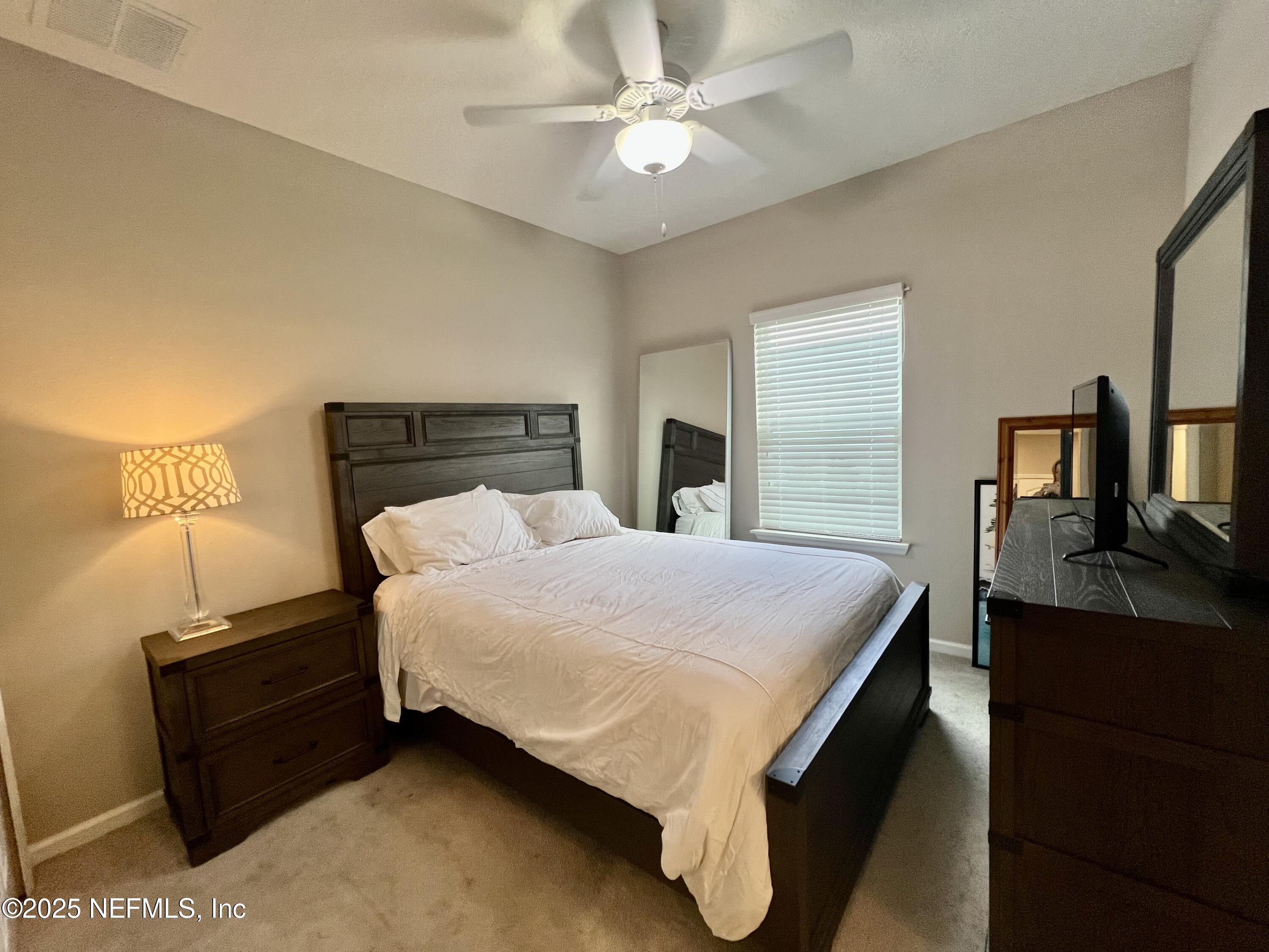 128 Ash Breeze Cove St. Augustine, FL 32095 - Photo 25 of 57 a bed sitting in a bedroom and night stand
