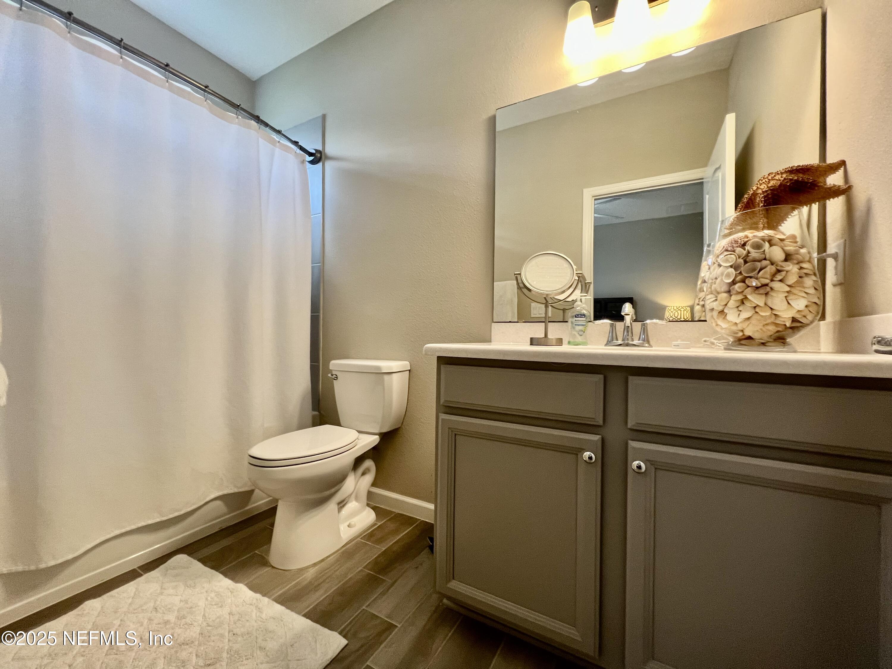 128 Ash Breeze Cove St. Augustine, FL 32095 - Photo 27 of 57 a bathroom with a toilet sink and mirror