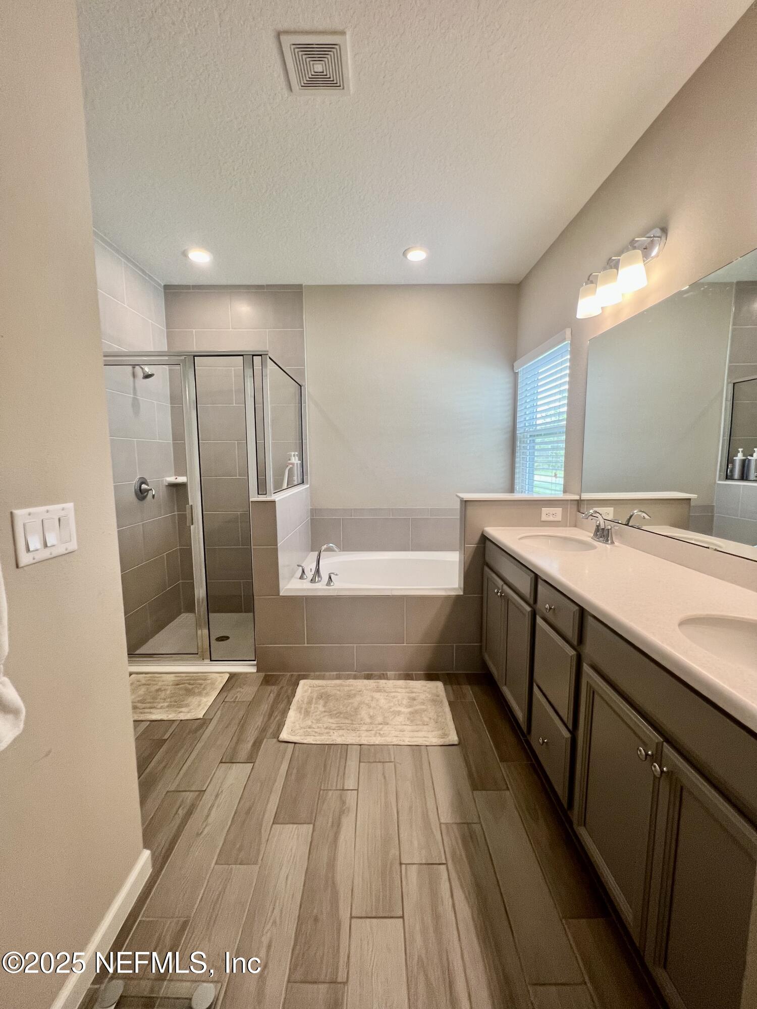 128 Ash Breeze Cove St. Augustine, FL 32095 - Photo 36 of 57 a spacious bathroom with a shower a sink and a mirror
