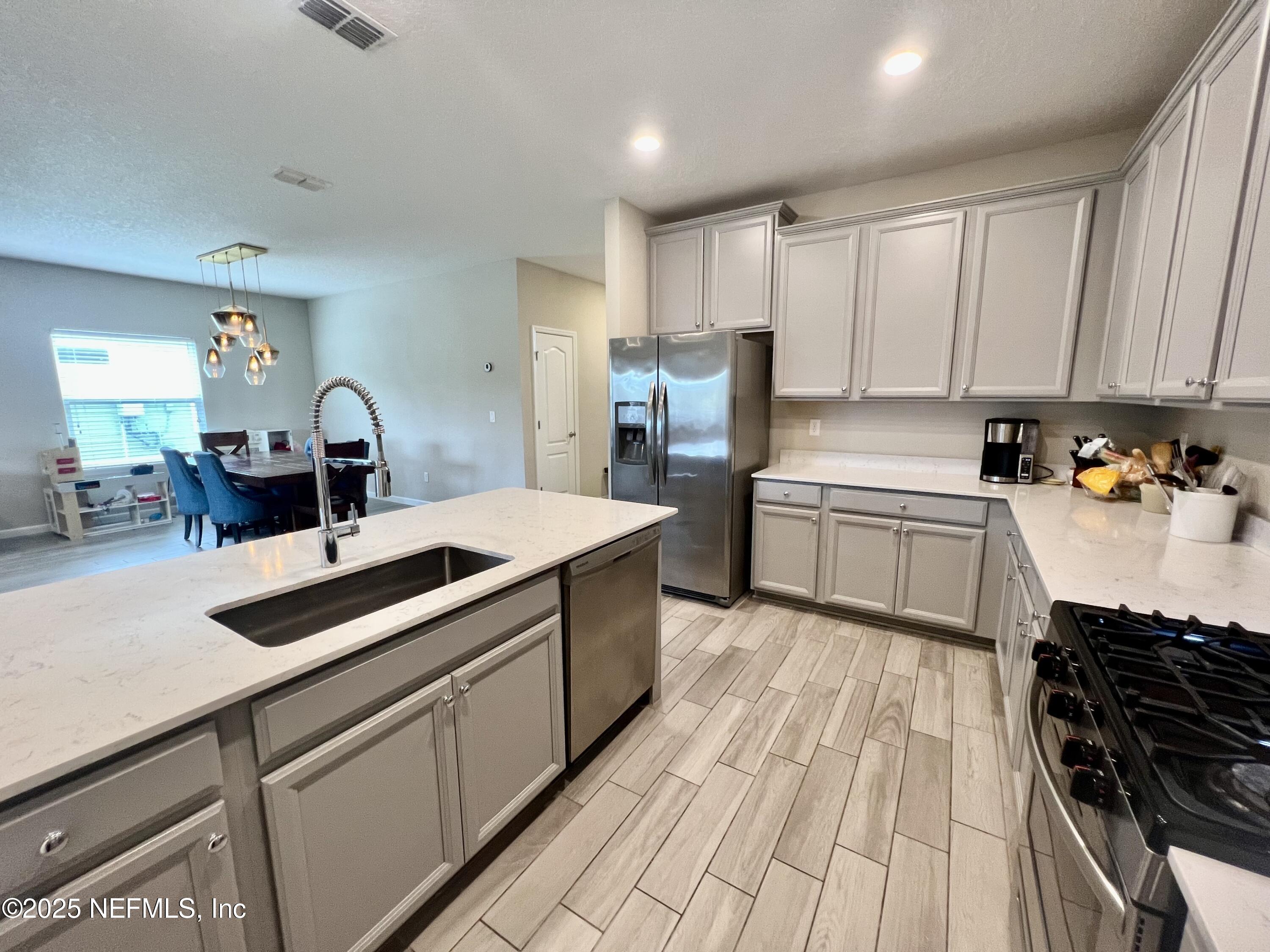 128 Ash Breeze Cove St. Augustine, FL 32095 - Photo 9 of 57 a kitchen with a sink stove and cabinets