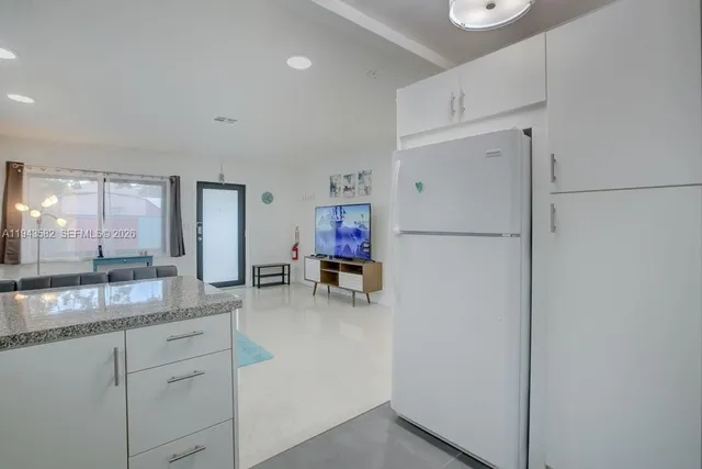 a kitchen with refrigerator and cabinets