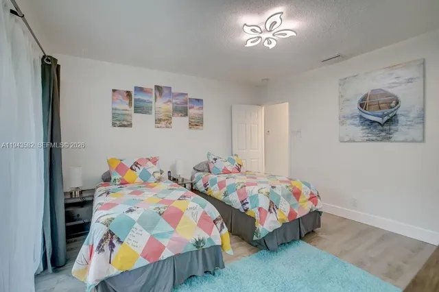 a bedroom with a bed and a lamp on dresser