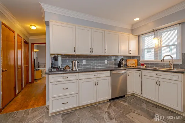 a kitchen with granite countertop a sink window and cabinets