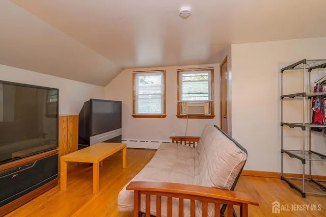 a living room with furniture flat screen tv and a window