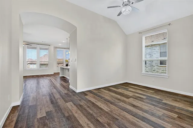 a view of a room with wooden floor and a ceiling fan