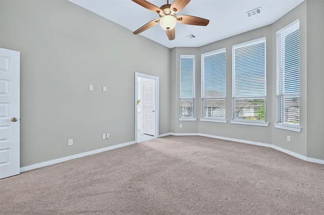 an empty room with closet and ceiling fan