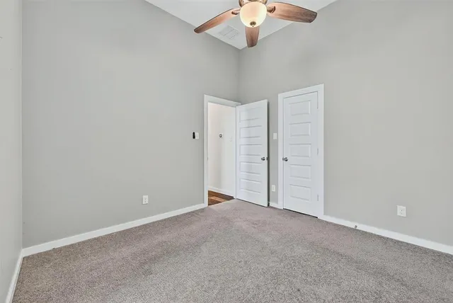 an empty room with a chandelier fan