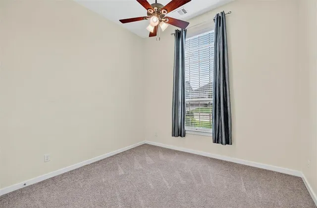 an empty room with a window and a fan